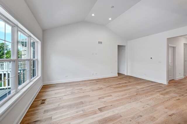 spare room featuring vaulted ceiling and light hardwood / wood-style flooring