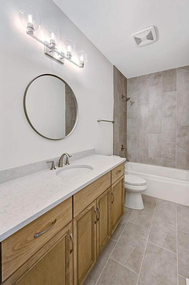 full bathroom featuring vanity, toilet, tile patterned floors, and tiled shower / bath