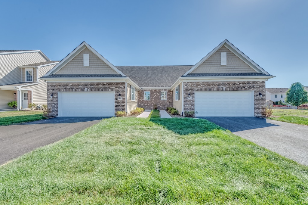 craftsman inspired home featuring a garage and a front lawn