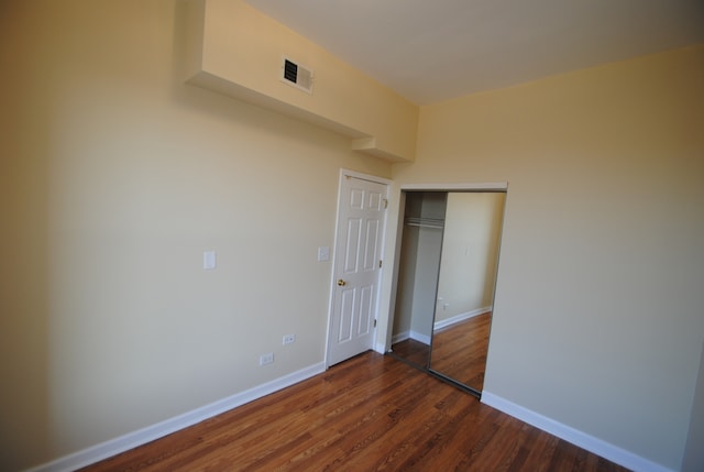 unfurnished bedroom with hardwood / wood-style flooring and a closet