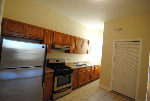 kitchen with appliances with stainless steel finishes, light tile patterned floors, and sink