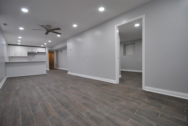 basement featuring dark wood-type flooring and ceiling fan