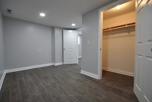 interior space with a closet, a spacious closet, and dark hardwood / wood-style flooring