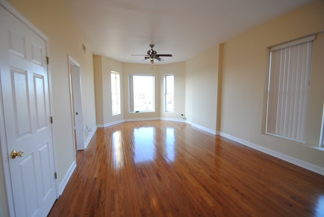 empty room with ceiling fan and dark hardwood / wood-style flooring