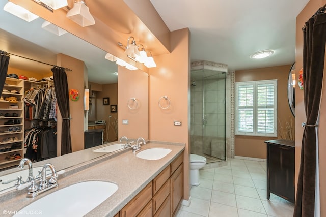 bathroom with tile patterned floors, vanity, toilet, and a shower with door