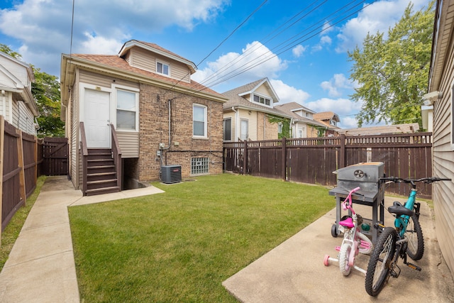 exterior space with cooling unit, a yard, and a patio