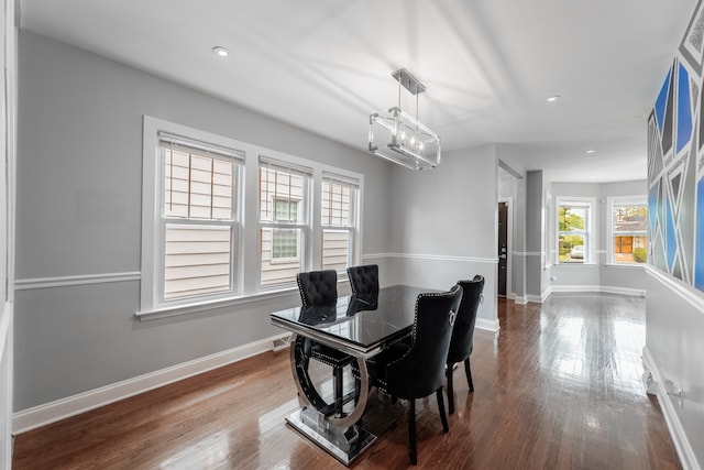 dining room with dark wood-type flooring and a notable chandelier