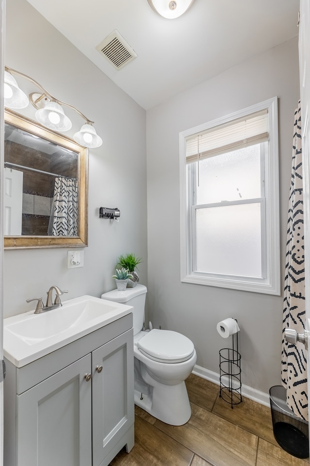 bathroom with vanity, toilet, and hardwood / wood-style floors