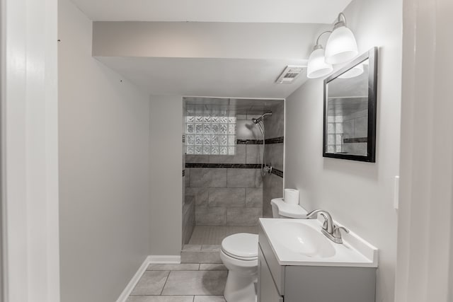 bathroom featuring tiled shower, vanity, toilet, and tile patterned floors