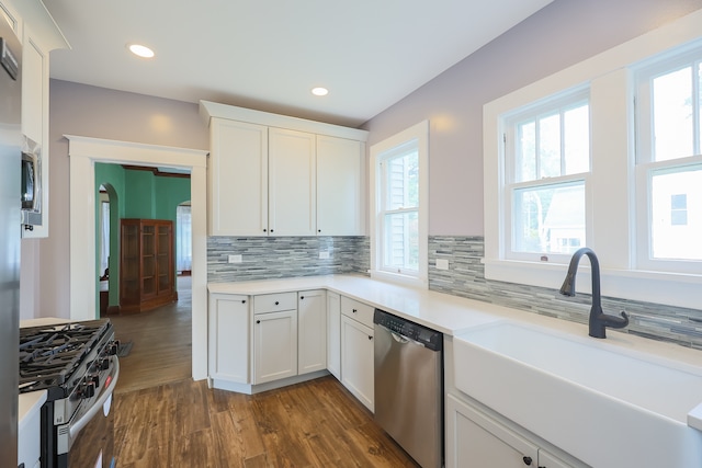 kitchen with stainless steel appliances, white cabinetry, and a wealth of natural light