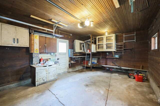 garage with a garage door opener and wood walls