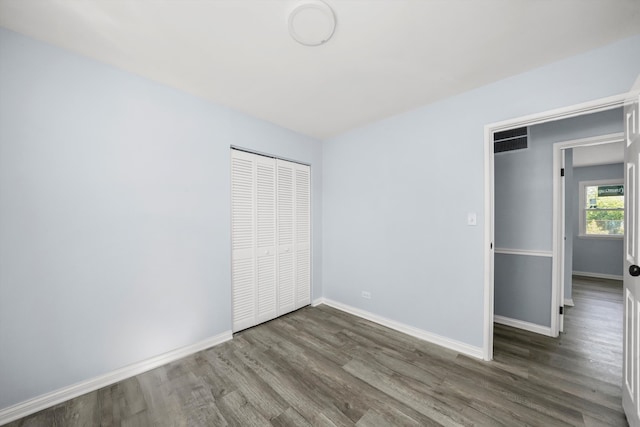 unfurnished bedroom featuring dark wood-type flooring and a closet