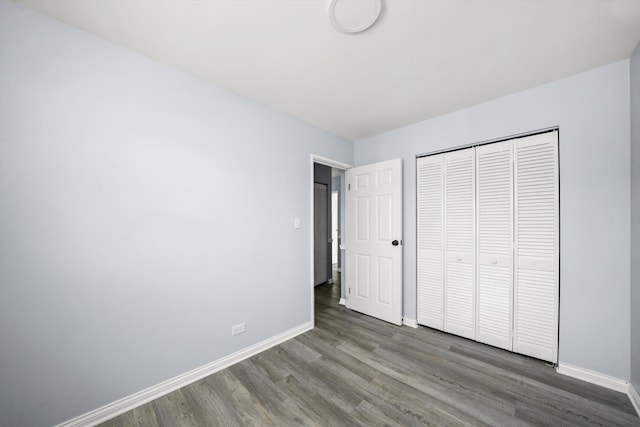 unfurnished bedroom with a closet and dark hardwood / wood-style flooring