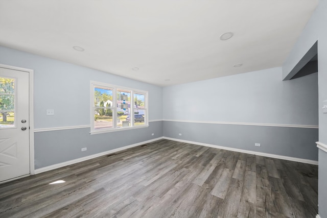 unfurnished room featuring dark hardwood / wood-style flooring and a healthy amount of sunlight