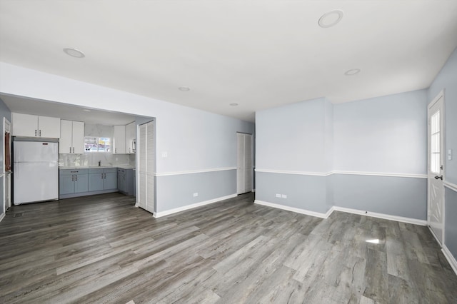 unfurnished living room with light wood-type flooring and sink