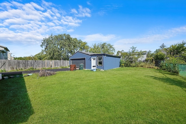 view of yard featuring a garage and an outbuilding