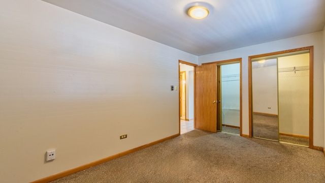 unfurnished bedroom with lofted ceiling, light colored carpet, and a closet