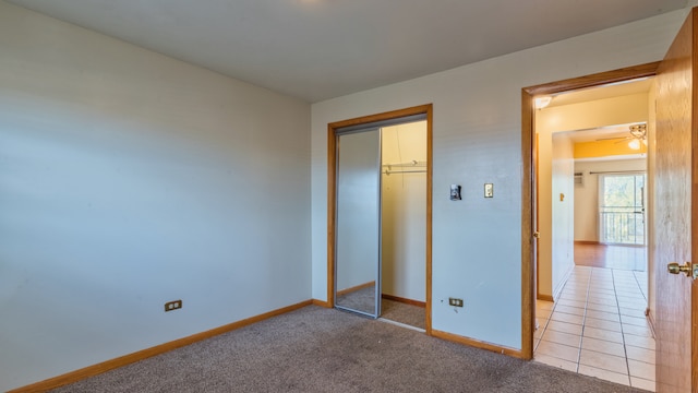 unfurnished bedroom with light colored carpet and a closet