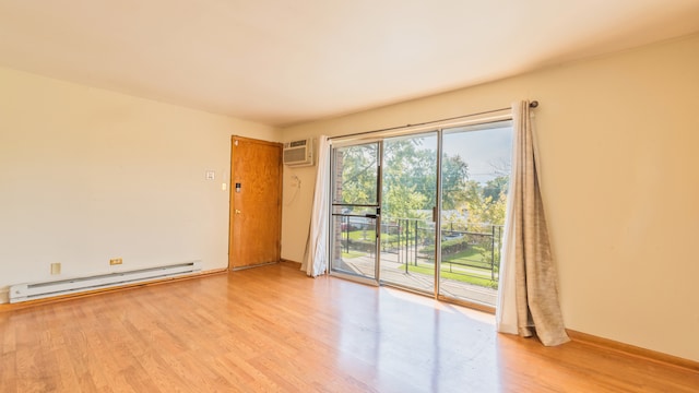 empty room featuring light wood-type flooring, baseboard heating, and a wall mounted AC