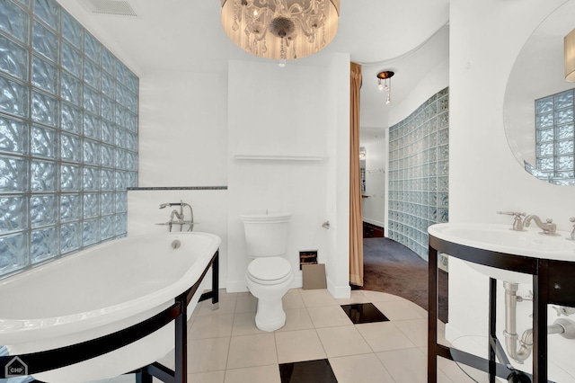 bathroom featuring tile patterned flooring, toilet, and a bathtub