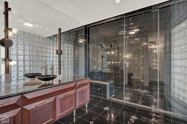 bathroom with vanity, tile walls, and walk in shower