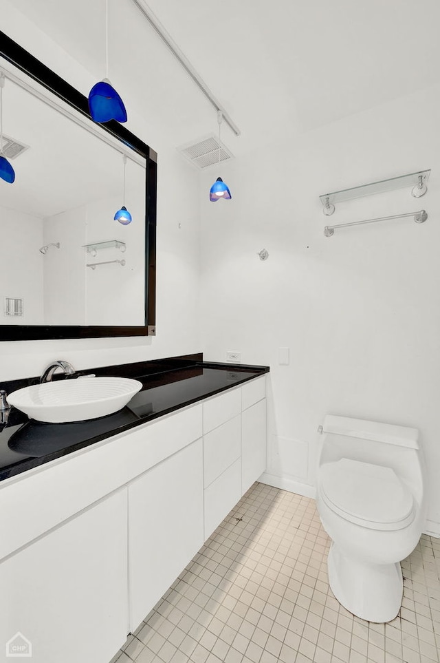 bathroom with tile patterned flooring, toilet, and vanity