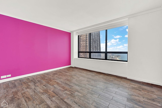 empty room with crown molding and hardwood / wood-style flooring