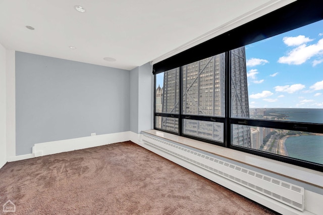 carpeted empty room featuring baseboard heating