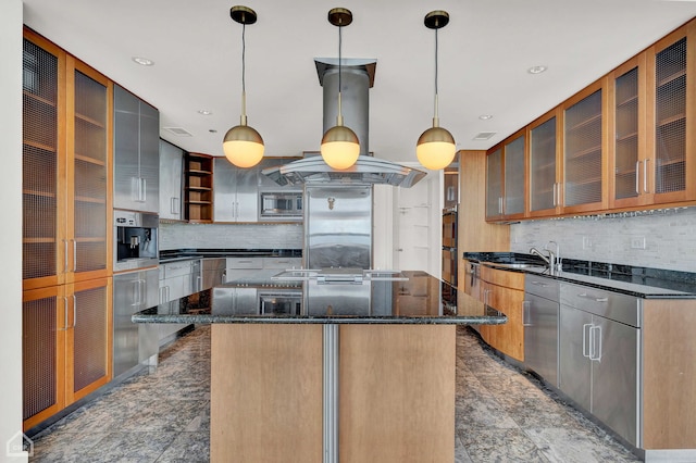 kitchen featuring a kitchen island, backsplash, dark stone counters, and island exhaust hood