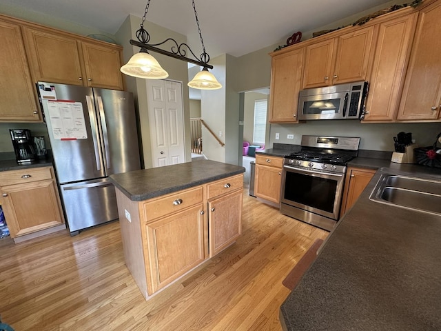 kitchen with decorative light fixtures, a center island, light wood-type flooring, and appliances with stainless steel finishes