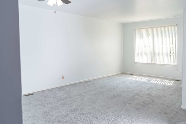 carpeted spare room with ceiling fan