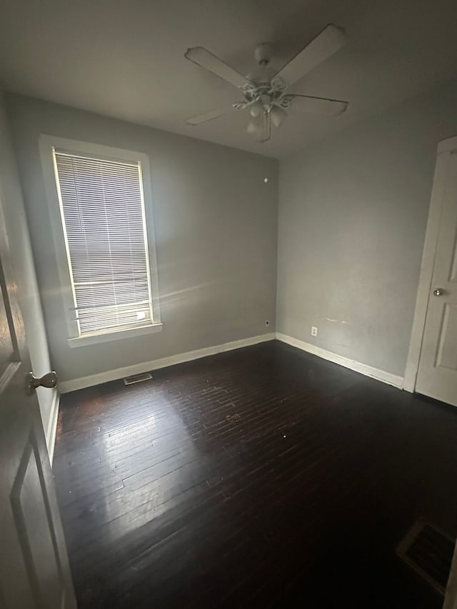 empty room with dark wood-type flooring and ceiling fan