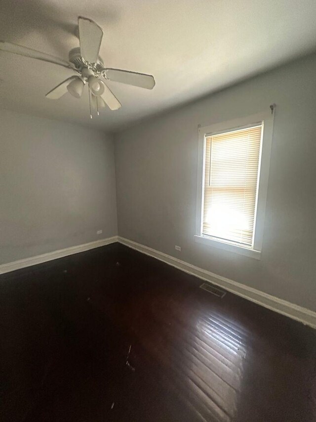 empty room with dark wood-type flooring and ceiling fan