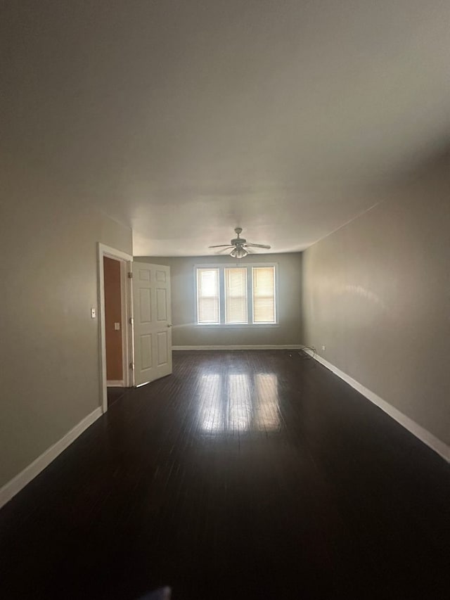 unfurnished room with dark wood-type flooring and ceiling fan