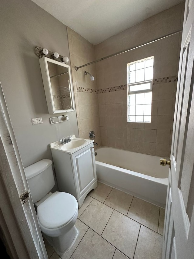 full bathroom featuring tiled shower / bath, vanity, toilet, and tile patterned flooring