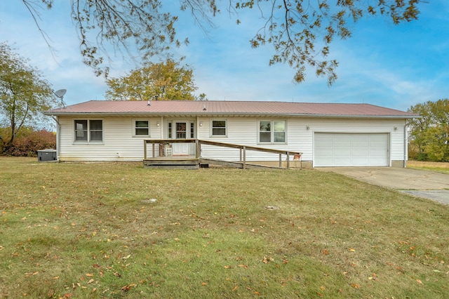 back of house with a wooden deck, a yard, and a garage