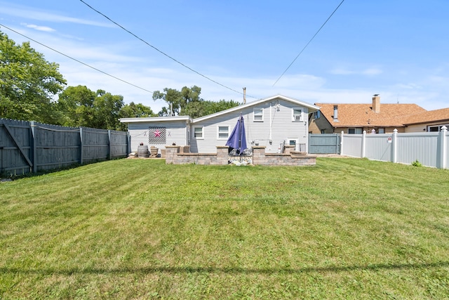 rear view of property with a yard and a patio