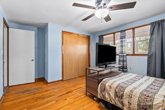 bedroom with light wood-type flooring, a closet, ceiling fan, and baseboards