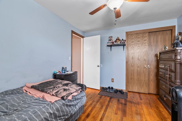 bedroom featuring dark wood-type flooring, a closet, and ceiling fan