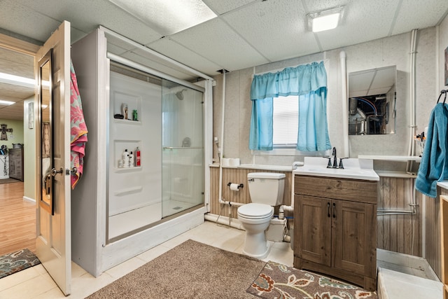 bathroom featuring a shower with door, toilet, a paneled ceiling, wood-type flooring, and vanity