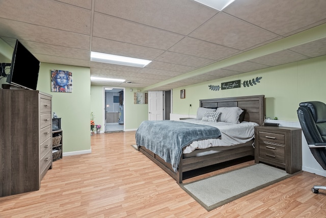 bedroom featuring a drop ceiling and light hardwood / wood-style floors