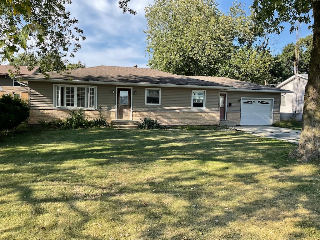 single story home featuring a garage and a front lawn