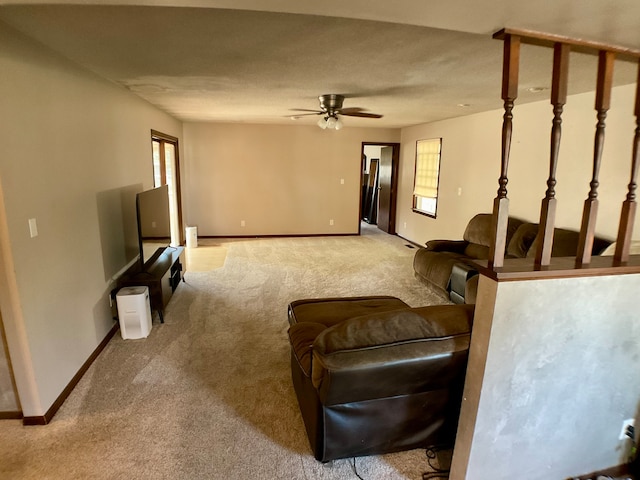 carpeted living room with ceiling fan and a healthy amount of sunlight