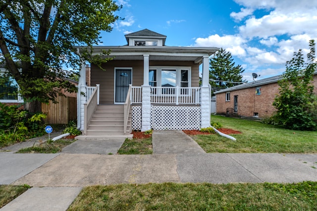 bungalow-style home with covered porch and a front lawn