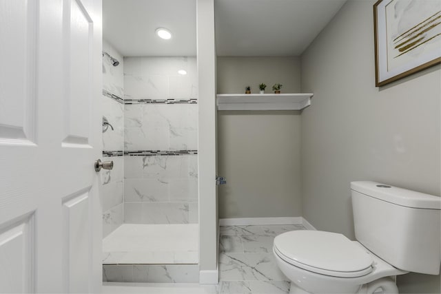 full bathroom with toilet, marble finish floor, baseboards, and tiled shower