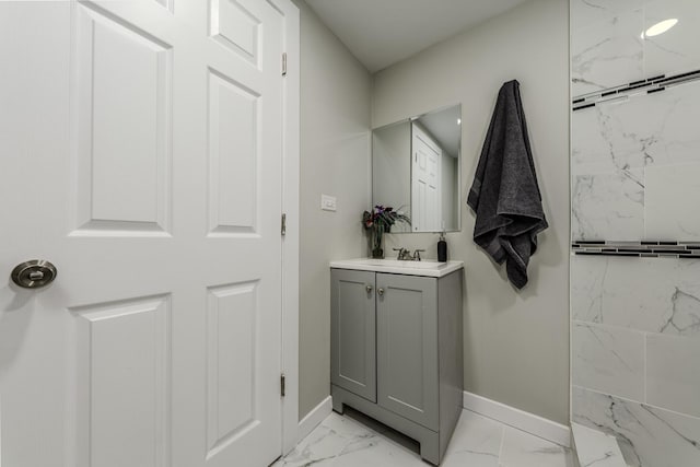 bathroom featuring marble finish floor, vanity, and baseboards