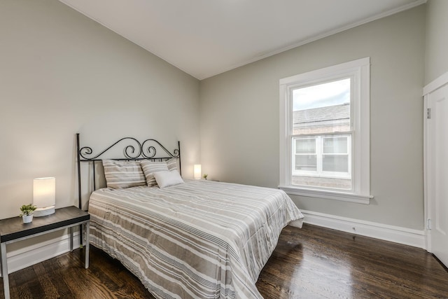 bedroom with wood finished floors and baseboards