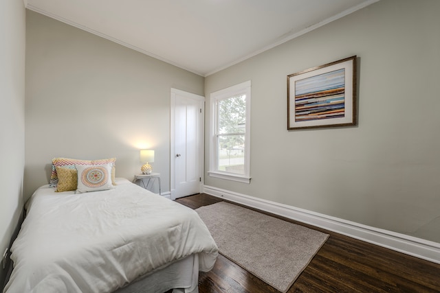 bedroom with ornamental molding and dark hardwood / wood-style flooring