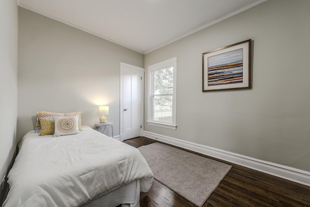 bedroom featuring dark wood-style floors, crown molding, and baseboards