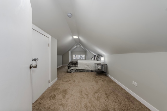 bedroom with light carpet and vaulted ceiling